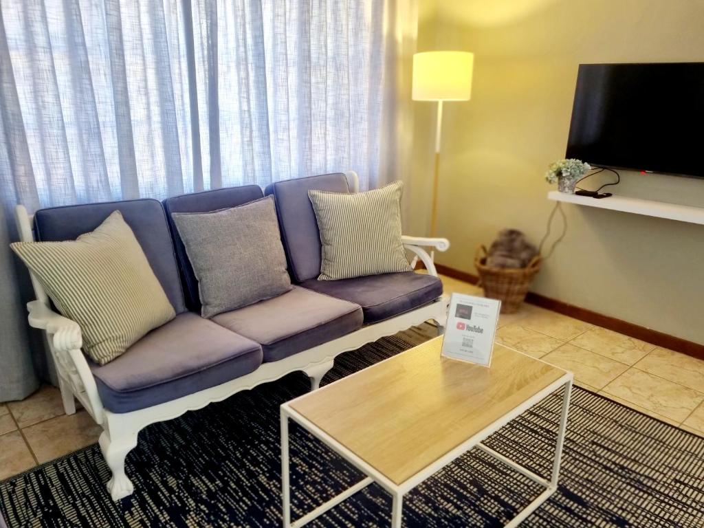 阿多Summerville Place的客厅配有紫色沙发和桌子