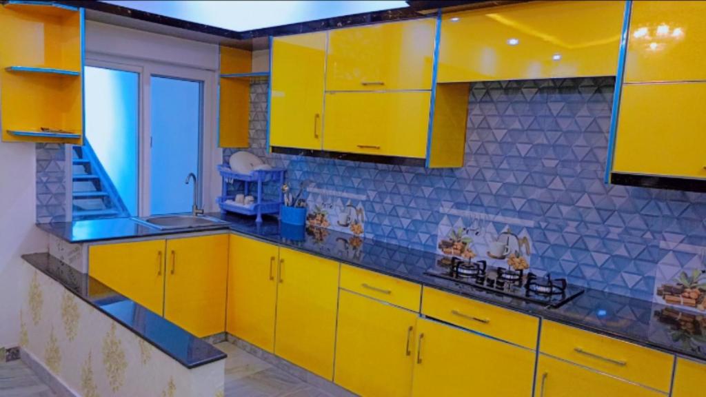 伊斯兰堡BED AND BREAKFAST ISLAMABAD - cottages的黄色的厨房,配有黄色橱柜和蓝色瓷砖