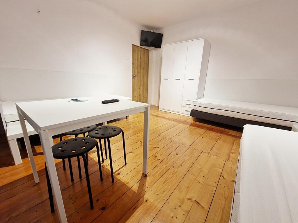 凯尔采Noclegi Kielce - Dom nad rzeką的一间设有一张白色桌子和两张凳子的房间
