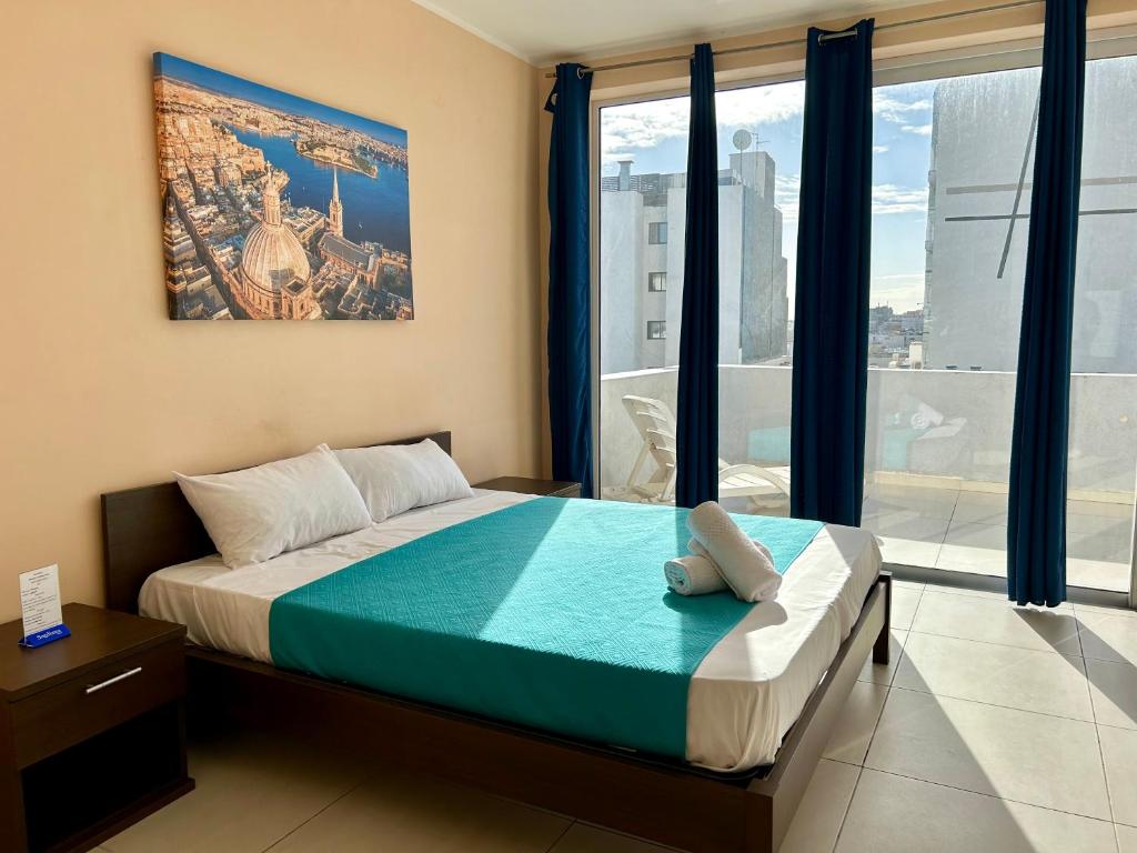 圣朱利安斯Malta Paradise Central Accomodation的一间卧室设有一张床和一个大窗户