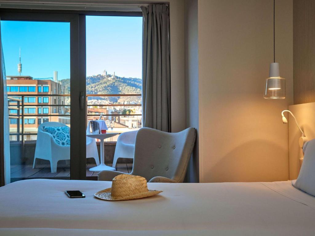 巴塞罗那巴塞罗那康多尔美居酒店的酒店客房设有一张床,享有阳台的景色