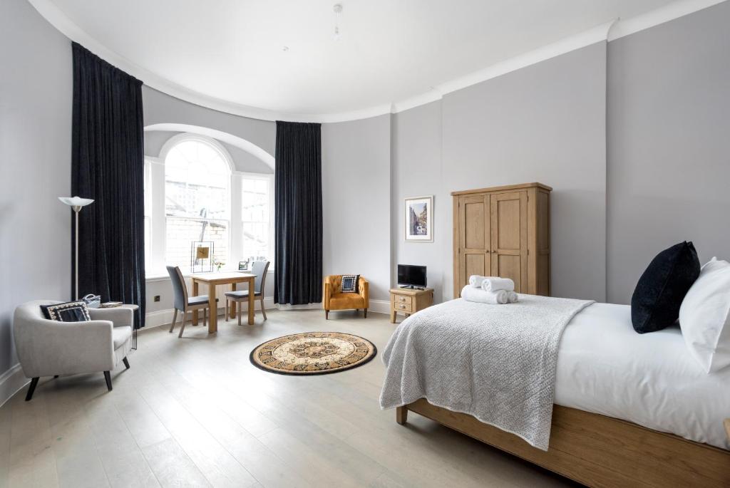 爱丁堡Modern George Street Studio sleeping 2的卧室配有一张床和一张桌子及椅子
