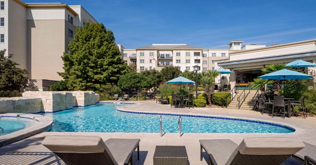 圣安东尼奥希尔顿圣安东尼奥山区酒店的一个带椅子和遮阳伞的游泳池