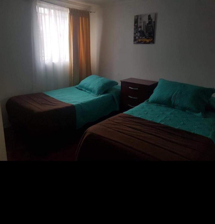 卡尔德拉Hospedaje GYT Caldera的两张床位于带窗户的房间内
