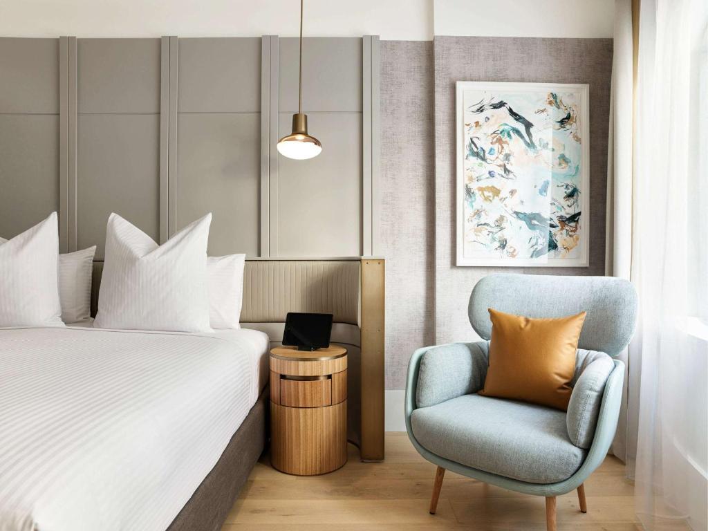 悉尼The Porter House Hotel Sydney - MGallery的配有一张床和一把椅子的酒店客房
