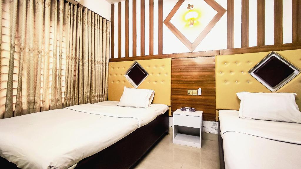 达卡White Rose Suites Ltd的小房间设有两张床,带两张床。