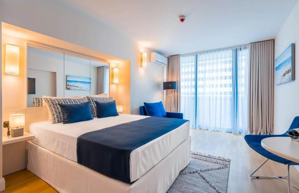 巴统Panorama Sea View Central City Batumi & ApartHOTEL的一间卧室配有一张带蓝色枕头的大床