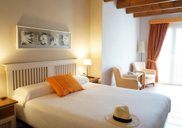 埃斯·梅卡达尔梅尔卡达尔酒店的一间卧室,配有一张床,上面有帽子