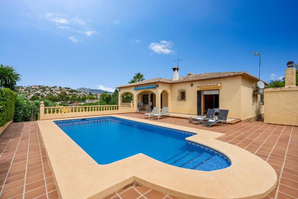 卡尔佩Villa Escudero - Plusholidays的一座带游泳池和房子的别墅