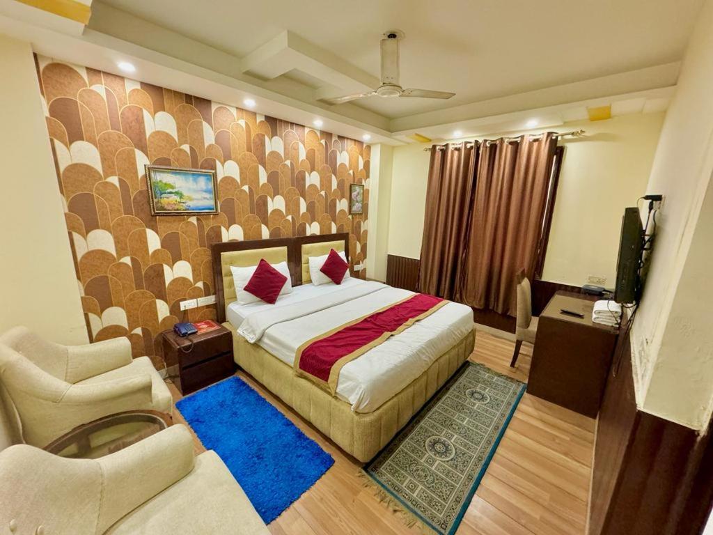 新德里Hotel Vista Inn, Karol Bagh, New Delhi - Near Metro的一间卧室配有一张床、一把椅子和电视