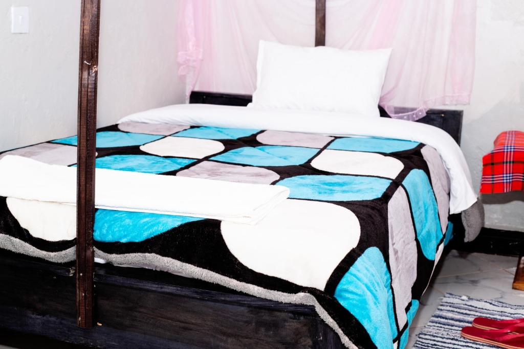 KimanaVINTEX GUEST HOUSE的一间卧室配有一张带五颜六色被子的床