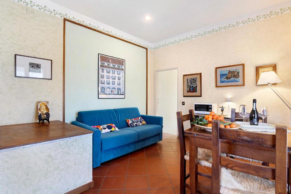 塞拉韦扎Casa tra gli ulivi vicino al mare的客厅配有蓝色的沙发和桌子