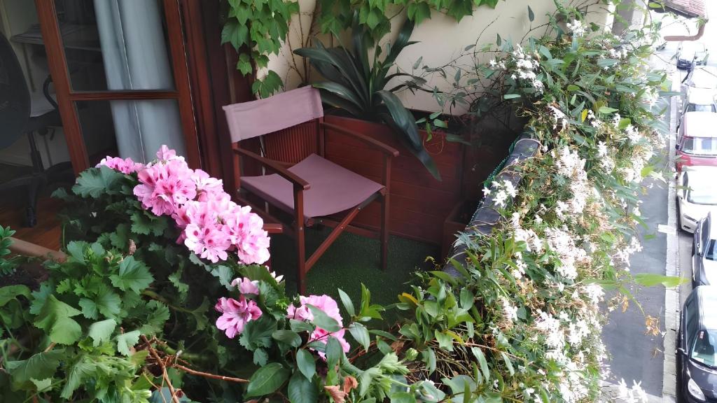 佛罗伦萨La casa dei fiori的鲜花门廊上的粉红色椅子