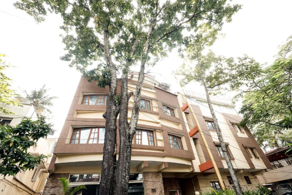 班加罗尔Falcon Suites Koramangala的前面有树木的建筑