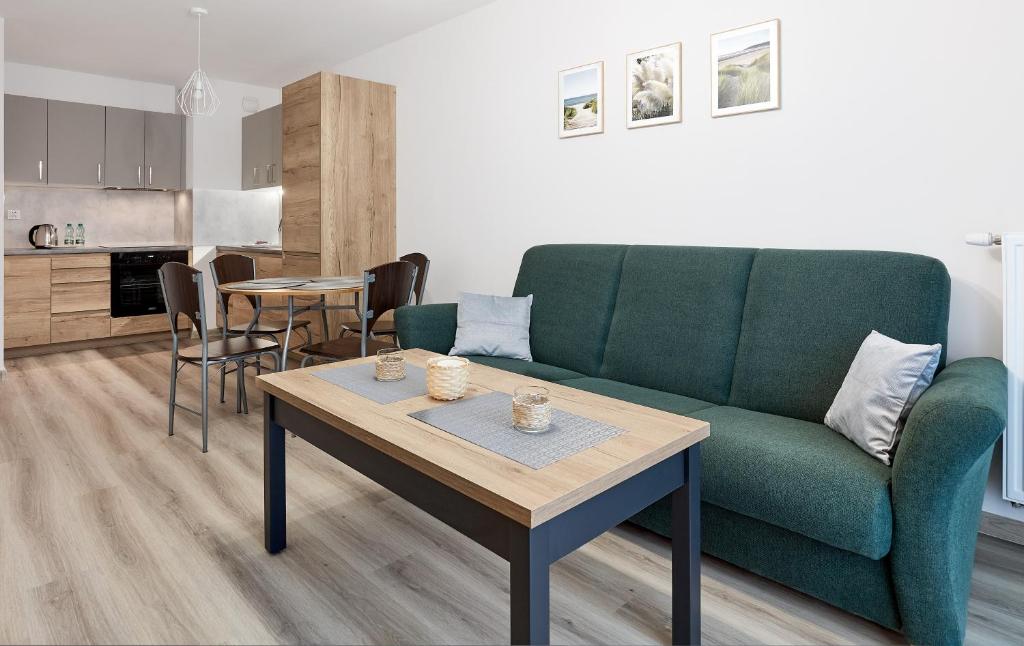 波兹南Poznań Airport Comfy Apartment的客厅配有绿色沙发和桌子