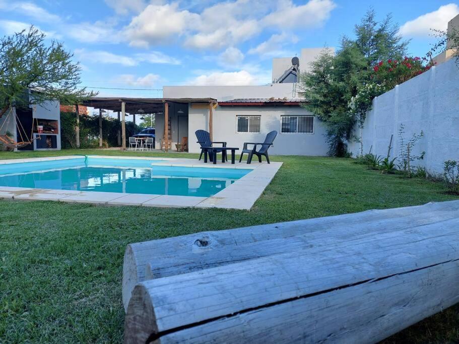 富内斯Casa en Funes. Pileta, Parrilla & Parque.的一个带游泳池和房子的后院