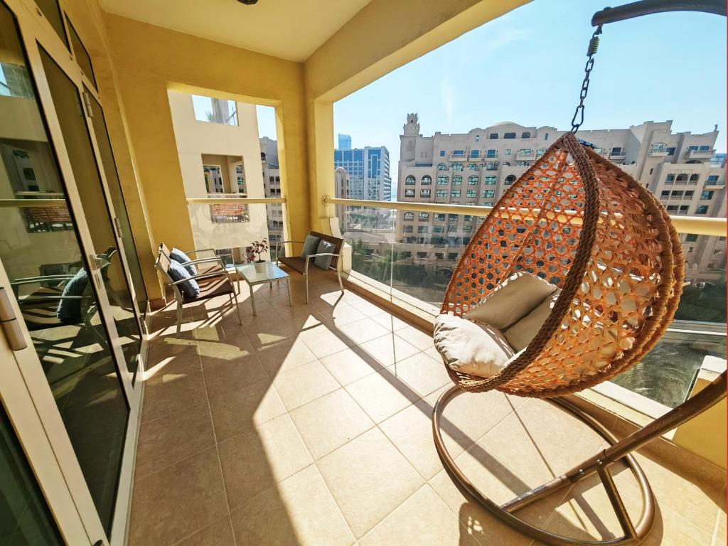 迪拜Seaside Serenity Residence Elegant 1BR Escape in Palm Jumeirah by La Buena vida holiday homes的配有大窗户的吊床