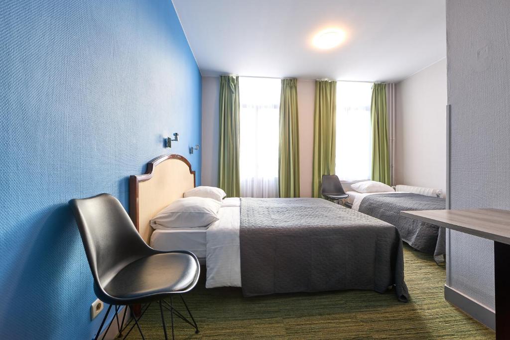 布鲁塞尔Hotel Derby MERODE的酒店客房设有两张床和蓝色的墙壁。