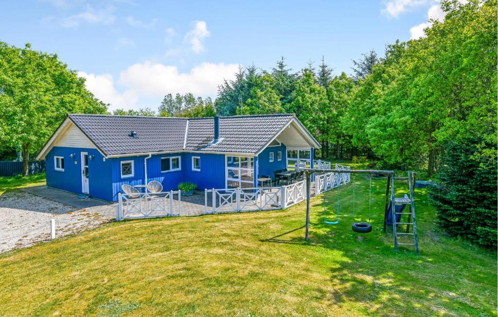 奥克斯伯尔Amazing Home In Oksbl With Wifi的一座蓝色的房子,在院子里设有游乐场