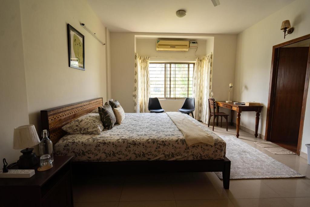 班加罗尔Luho 306的一间卧室配有一张床、一张书桌和一个窗户。