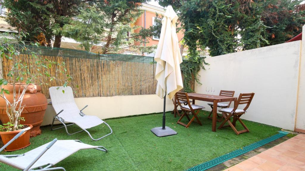 ElmasWelcomely - Villino Octagon的庭院配有桌椅和遮阳伞。