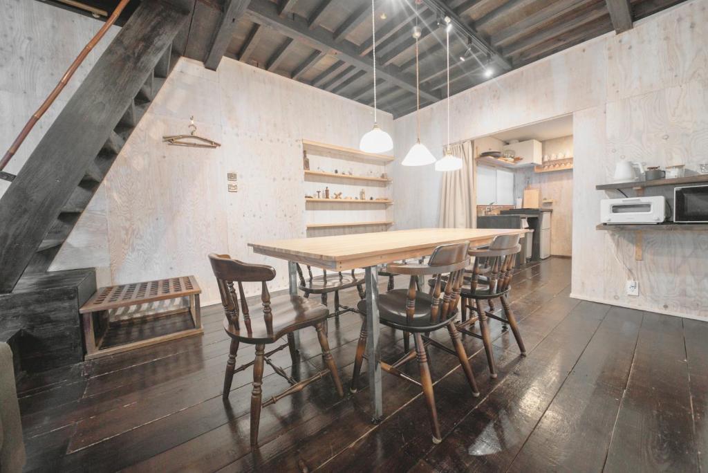 金泽YADOSU Arts and Stay的一间带木桌和椅子的用餐室