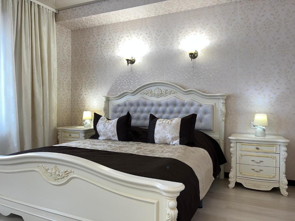 卢茨克Maximus hotel的一间卧室设有一张大床和两个床头柜