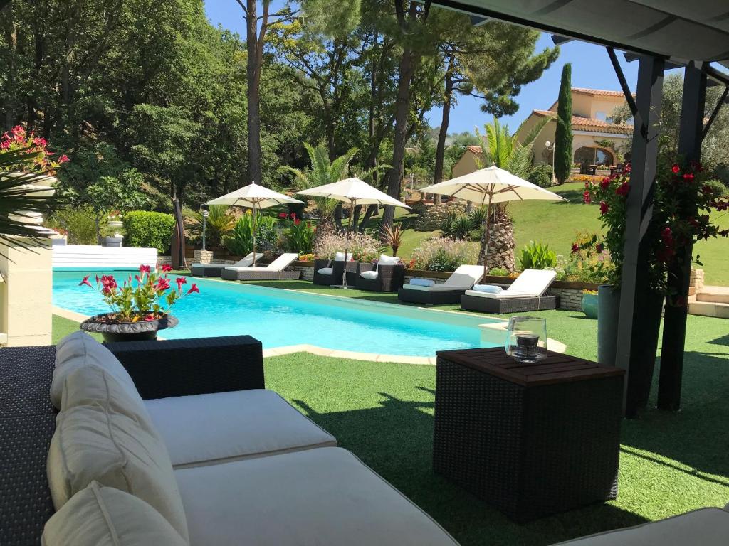 RoussasLe Mas de l'Alliance - 12 p - Air Cond - private Pool - near Grignan的庭院内一个带沙发和遮阳伞的游泳池