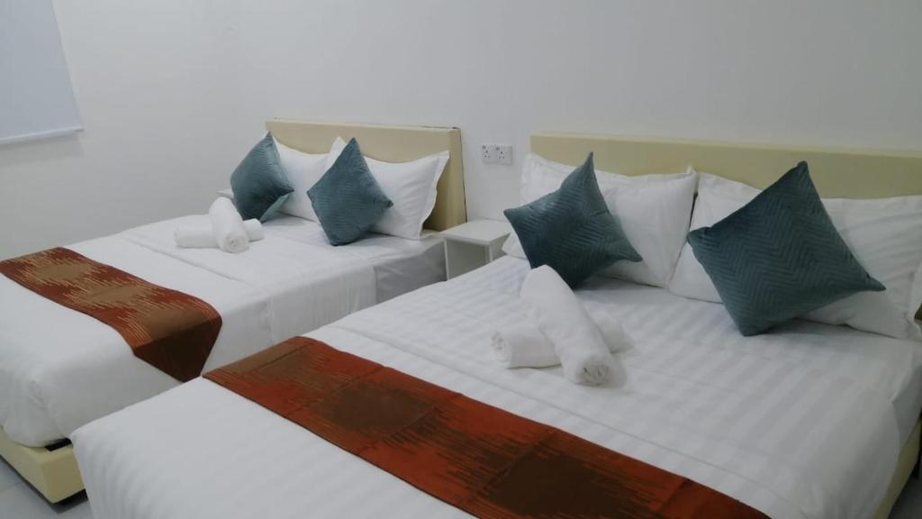 怡保SKYN SMART HOME的两张带蓝色和白色枕头的床