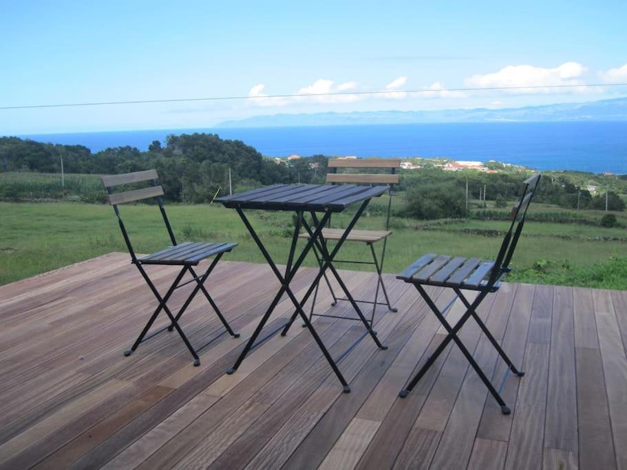 圣罗克杜皮库Casa dos Vimes - mar e céu的甲板上的野餐桌和两把椅子