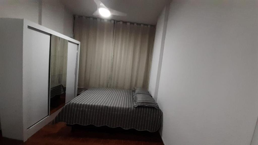 里约热内卢studio的一间小卧室,配有一张床和镜子