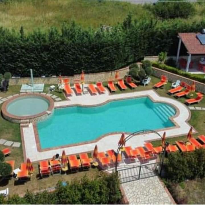 Sogni d'insonnia的享有带橙色椅子的游泳池的顶部景致