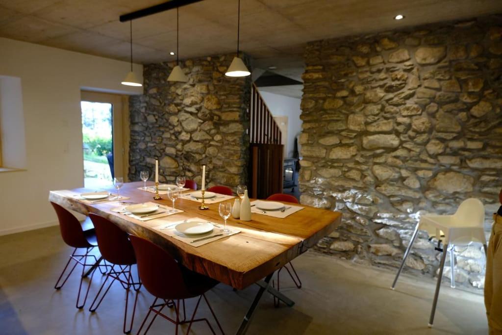 锡永Maisonnette de campagne的石墙客房内的大木桌