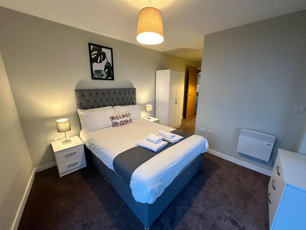 曼彻斯特Adelphi Wharf Apartments by Beehosting的一间卧室配有一张床,上面有两条毛巾