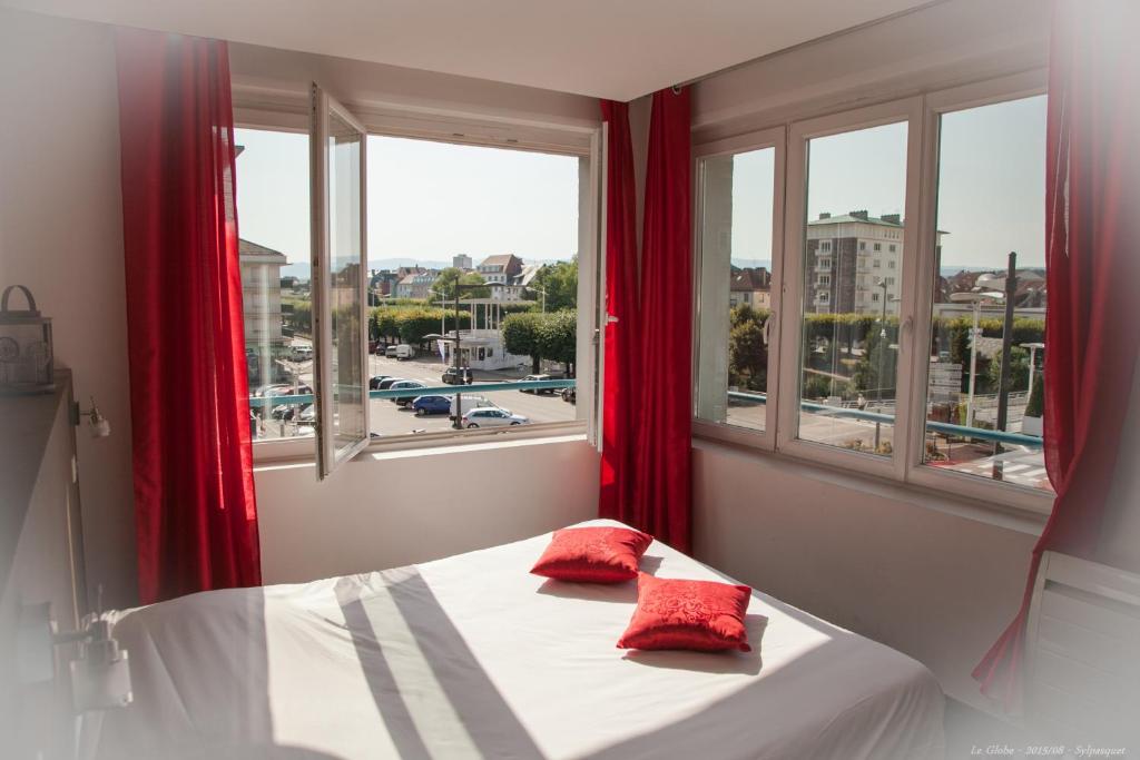 圣迪耶地球酒店酒吧的窗户客房内的一张带红色枕头的床