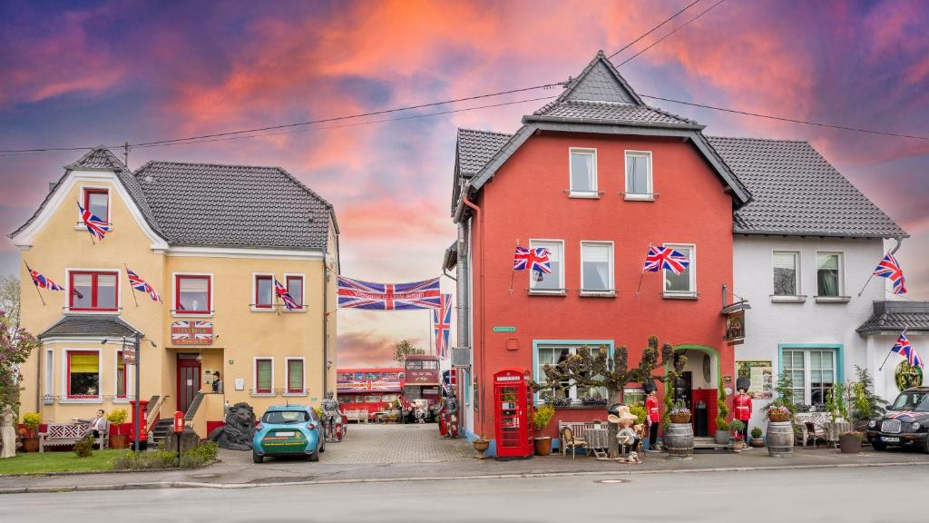 莱茵河畔林茨The Little Britain Inn Themed Hotel One of a Kind In Europe的一座有房子和汽车的小镇的画