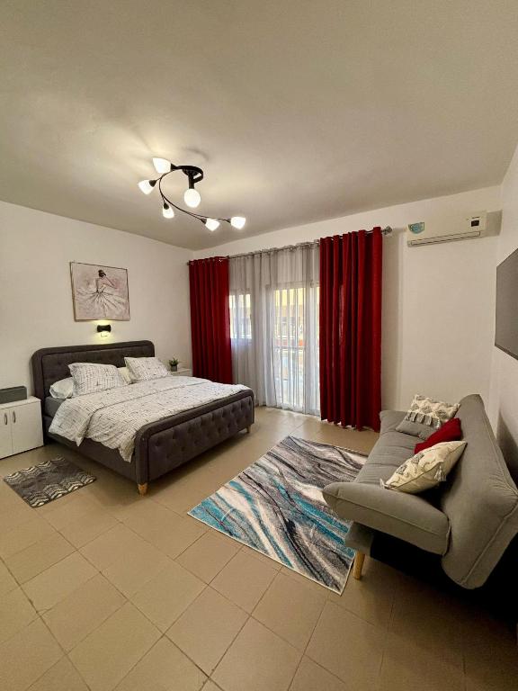 达喀尔Le Dakar Roi - Studio Centre Ville Très Bien Situé的一间卧室配有一张床和一张沙发