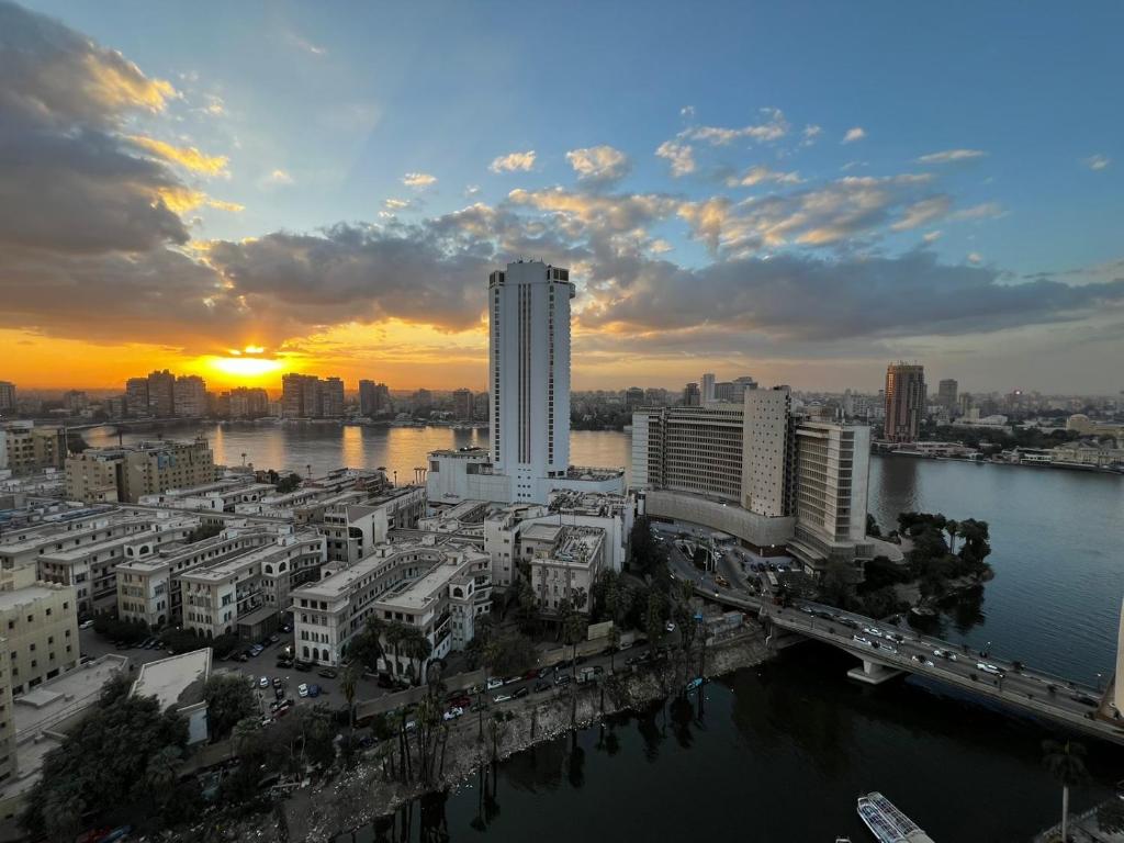 开罗Nile view apartment的河上城市的日落和建筑