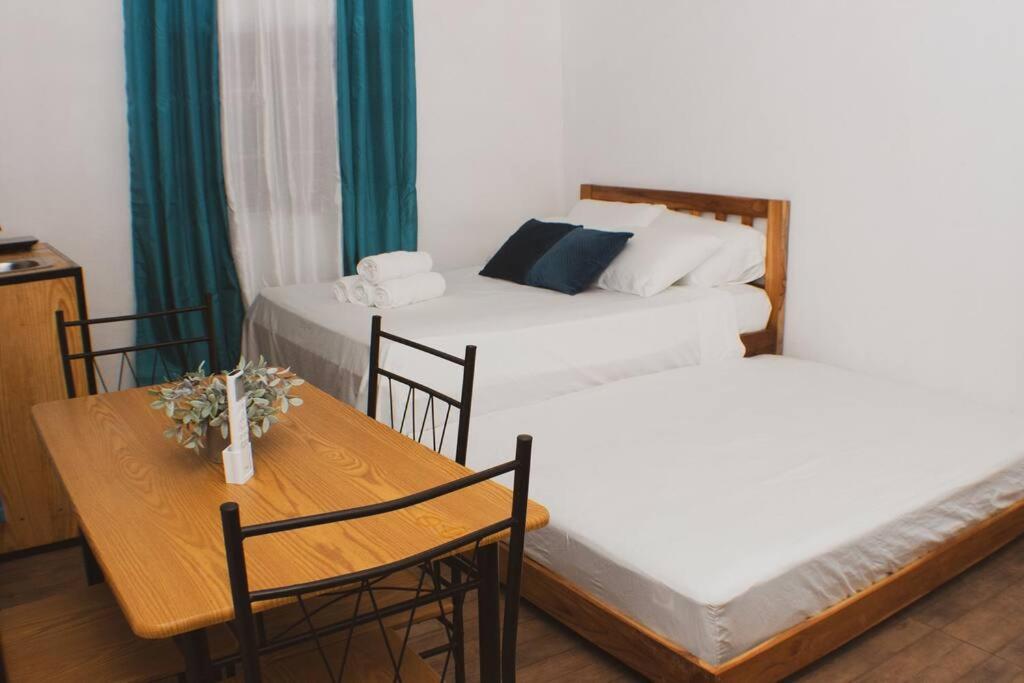 Salamanca Loft的客房设有两张床、一张桌子和一张桌子以及椅子。