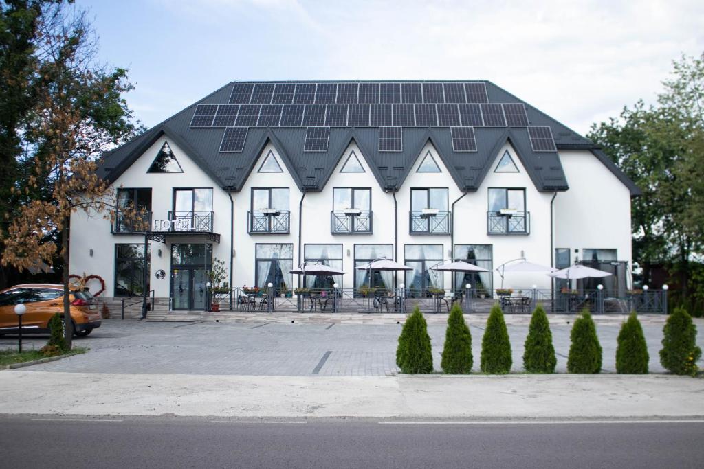 BushtynoГотельно-ресторанний комплекс Фамілія的一座大型白色建筑,屋顶上设有太阳能电池板