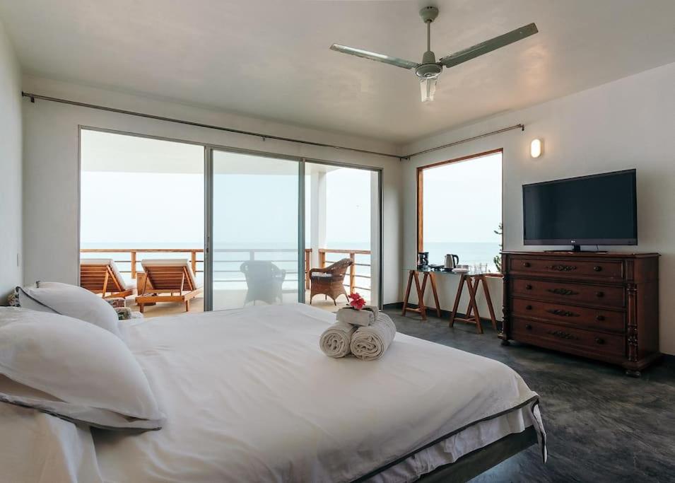 曼克拉Marmot Seashore Moonset Suite的一间卧室配有一张大床和一台平面电视