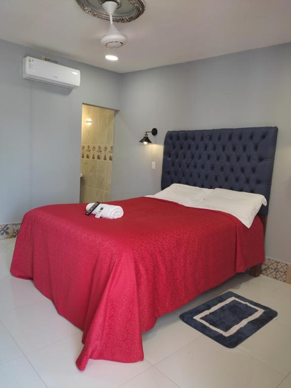 里瓦斯HOSTAL RIVAS INNS的一间卧室配有红色的床和红色毯子