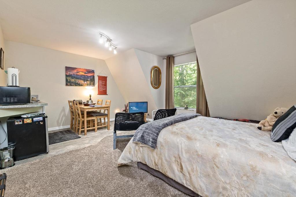 阿什福德Mountain Meadows Inn & Chalet Suites的一间卧室配有一张床和一张书桌及电视