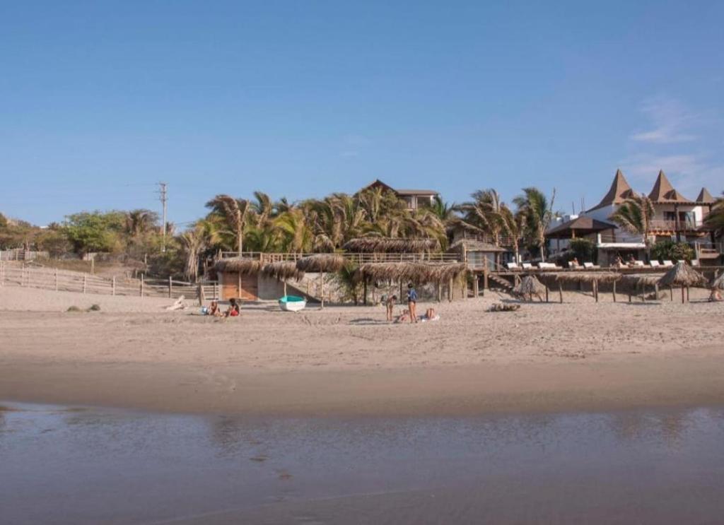 维加伊托La Cabaña del Mar Vichayito的一片棕榈树海滩,沙滩上的人