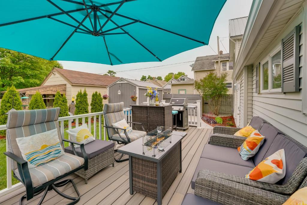 马尼斯蒂Dog-Friendly Manistee Home with Deck, 2 Mi to Beach!的庭院配有桌椅和遮阳伞。