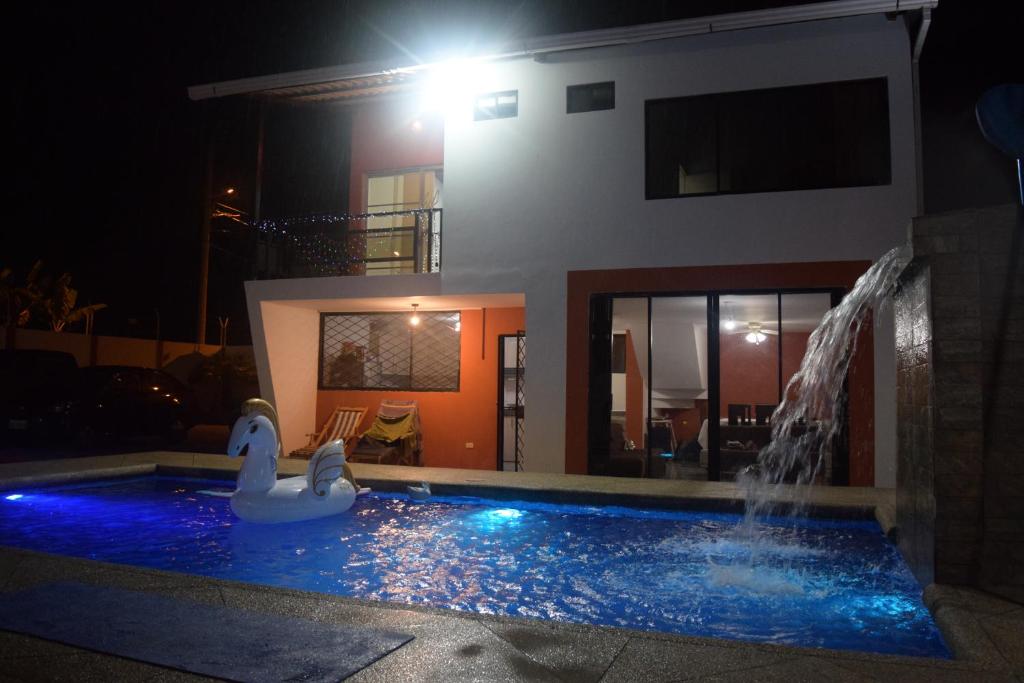 通苏帕Casa privada en Tonsupa con piscina的房屋前的游泳池,有天鹅