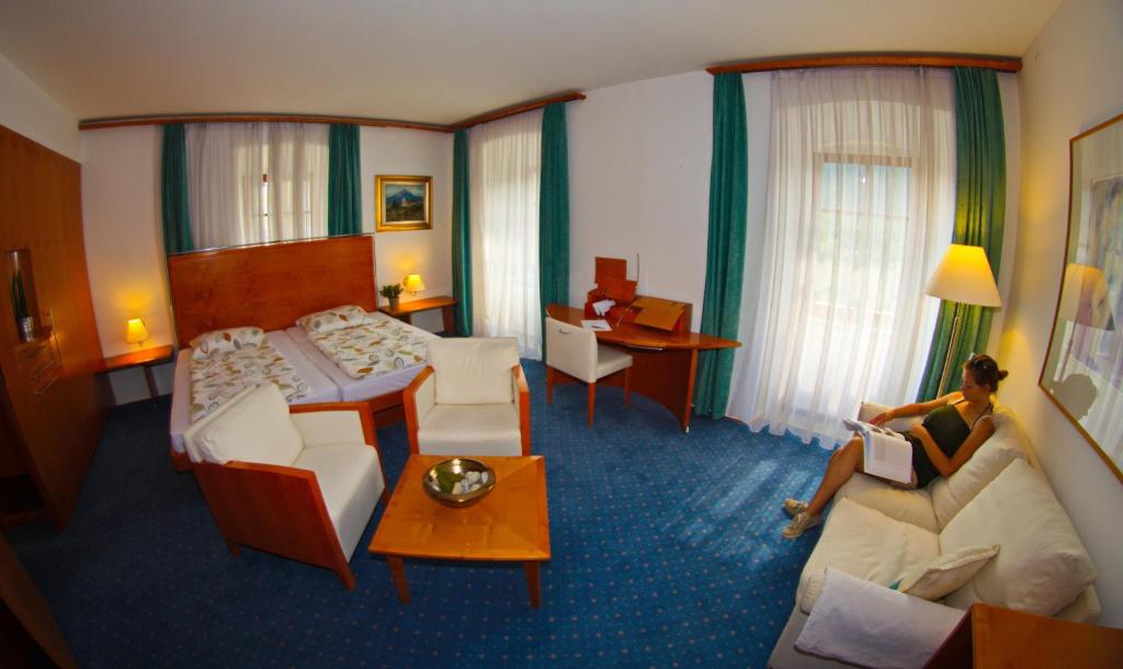 拉什科Rooms Savinja的坐在酒店房间床上的女人