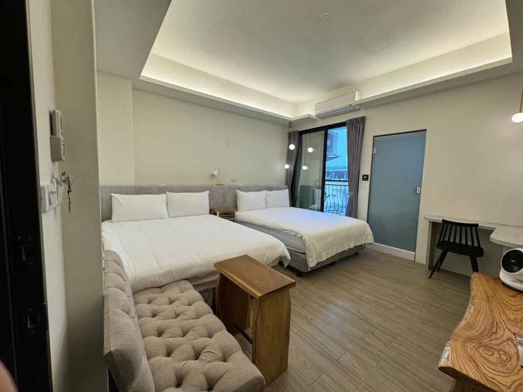 台东飛行船電梯民宿的酒店客房,设有两张床和一张沙发