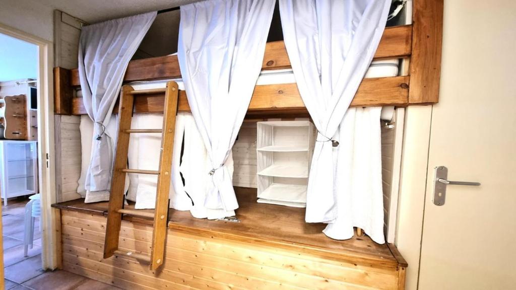 皮伊圣万桑Résidence Valgardena - Appartements pour 4 Personnes 471的客房设有两张双层床和白色窗帘
