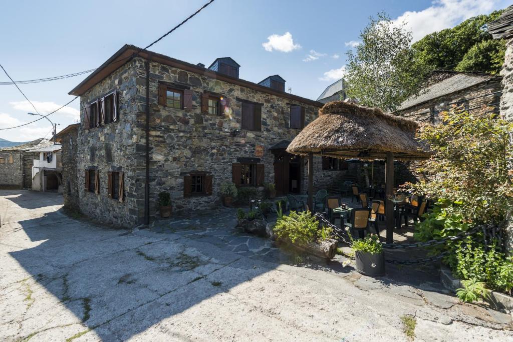 Pereda de Ancares安卡雷斯谷乡间酒店的一座带茅草屋顶的古老石头房子